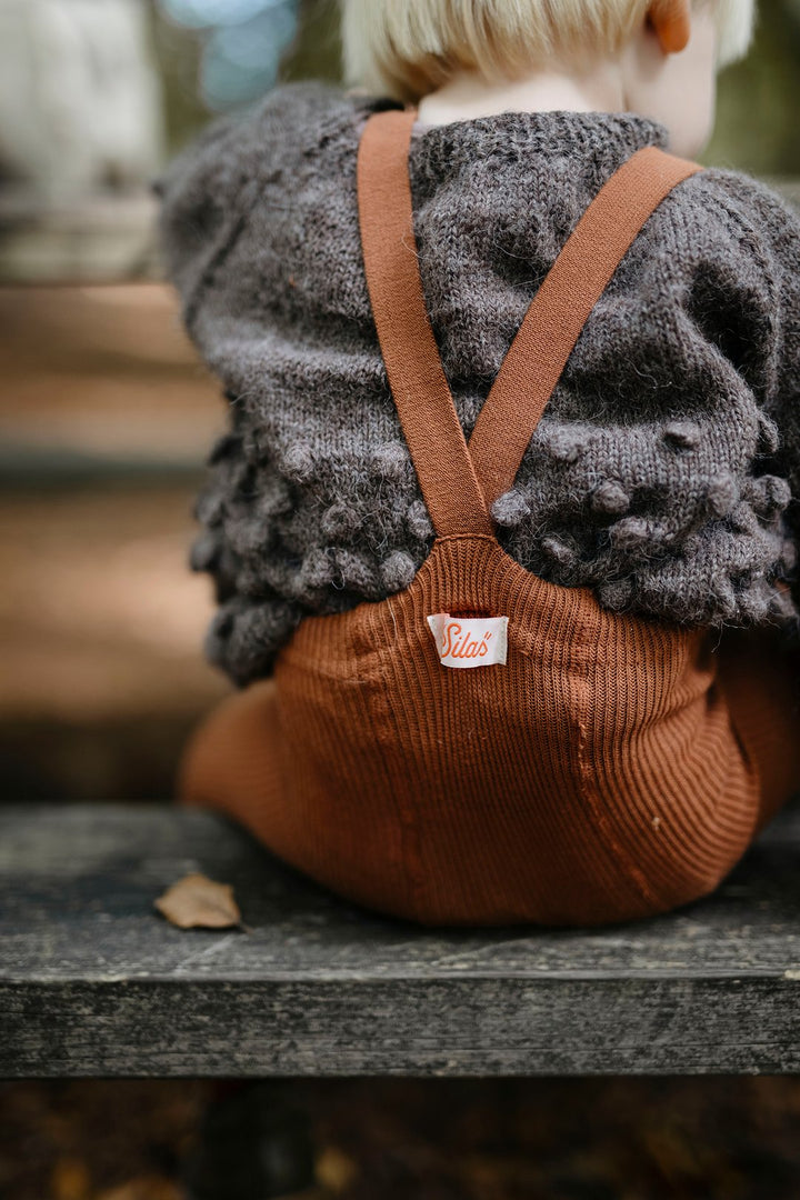 Blonde toddler boy wearing Silly Silas brown cinnamon cotton ribbed tights with braces/suspenders