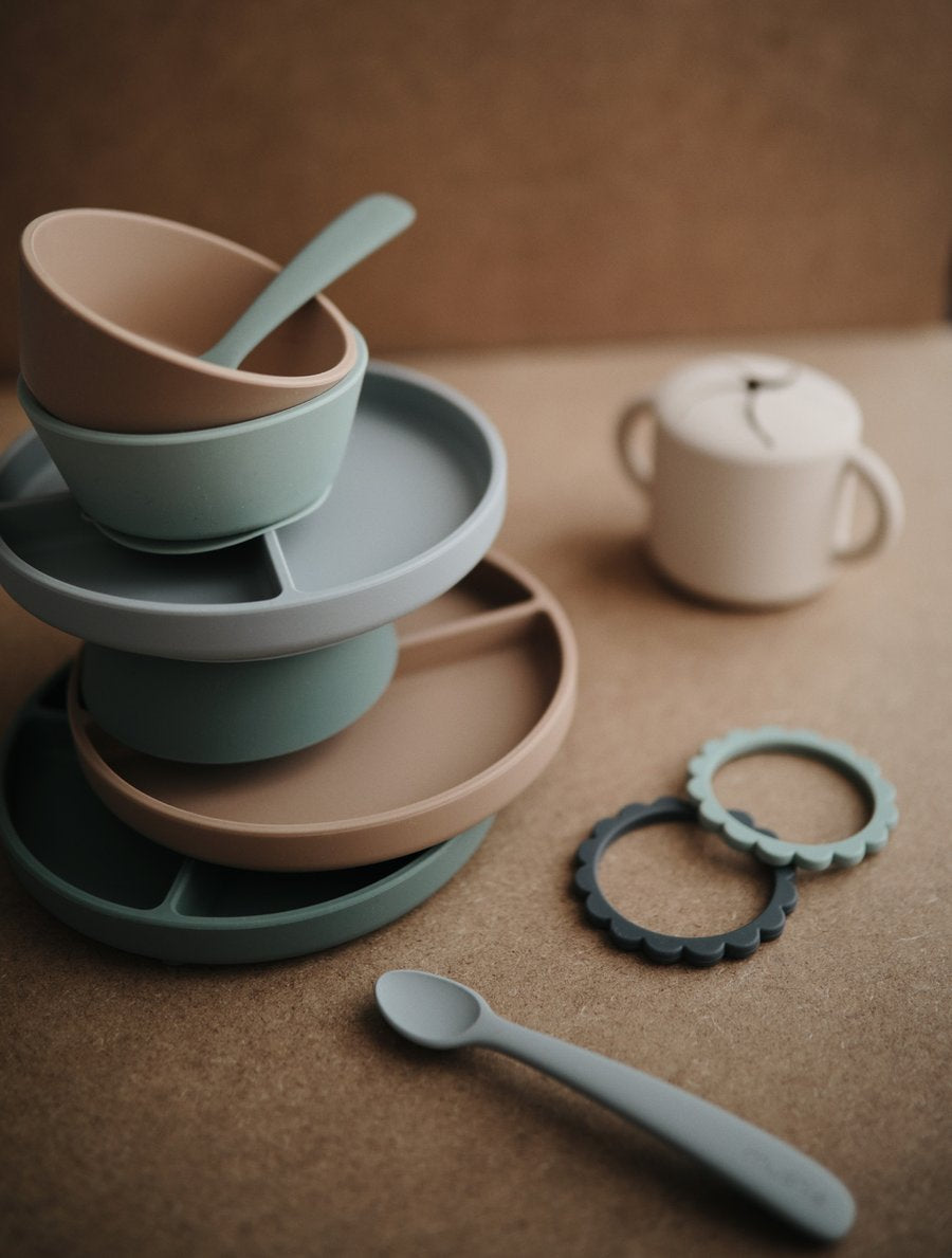 Stack of divided plates, bowls and spoons 