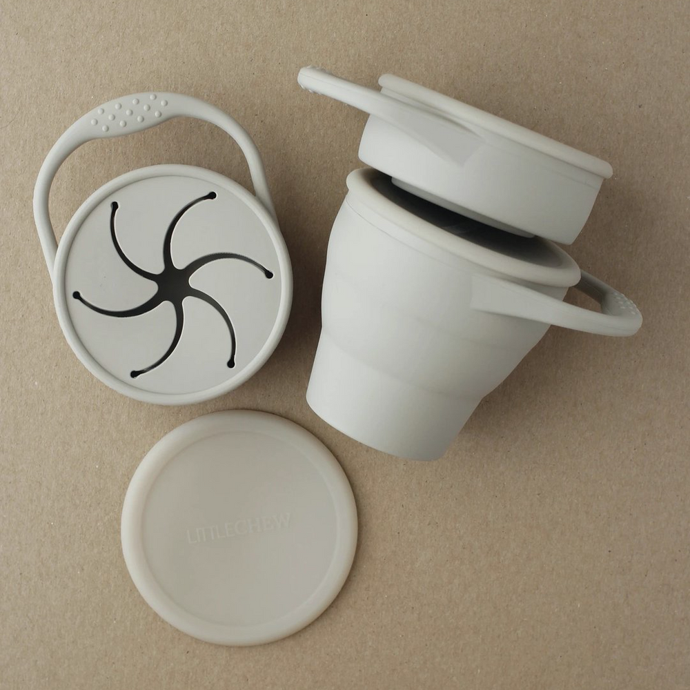 Toddler foldable silicone snack cup with hand in taupe grey