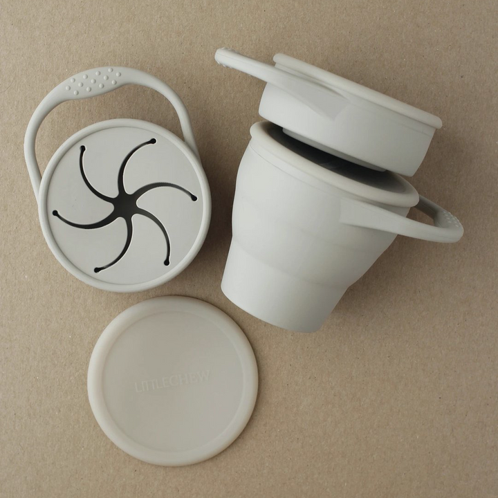 Toddler foldable silicone snack cup with hand in taupe grey