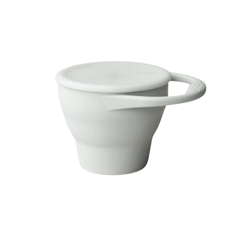 Toddler foldable silicone snack cup with hand in taupe grey
