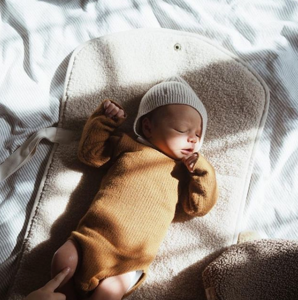 Baby in mustard yellow roper and white beanie sleeping on Beige white cream ecru  chunky teddy change mat portable with strap