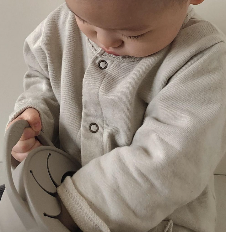 Toddler eating snacks from silicone snack cup on the go