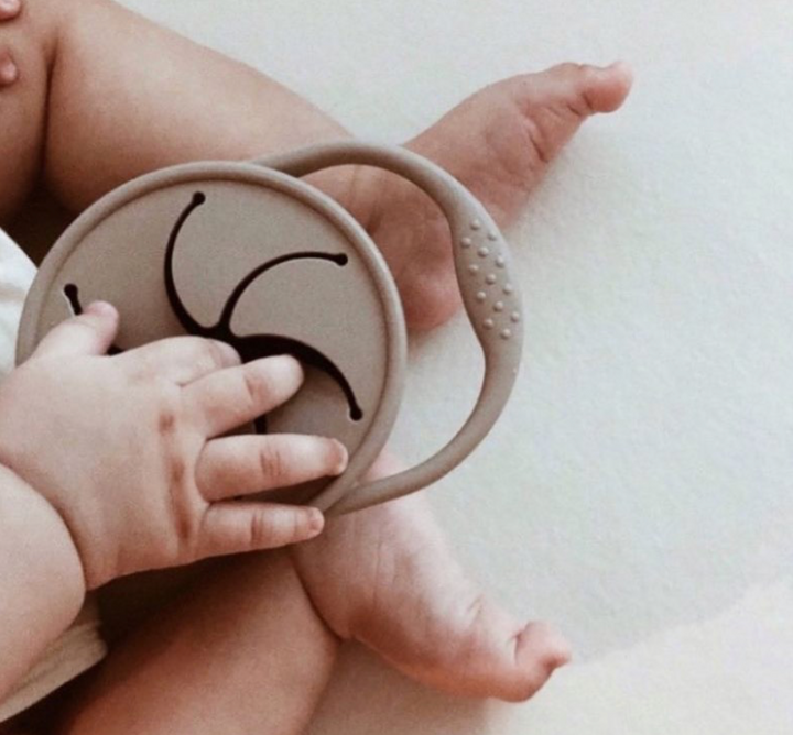 Toddler eating from silicone snack cup with handle and lid