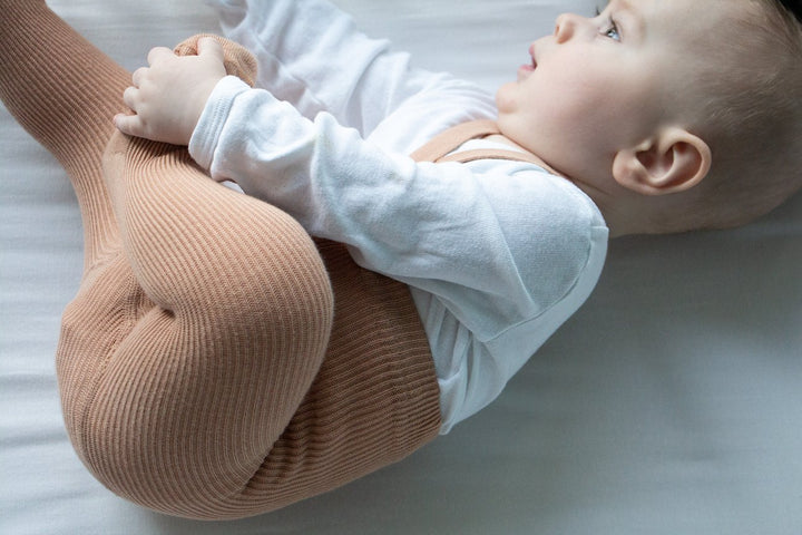 Baby wearing Silly Silas light brown rib tights with braces