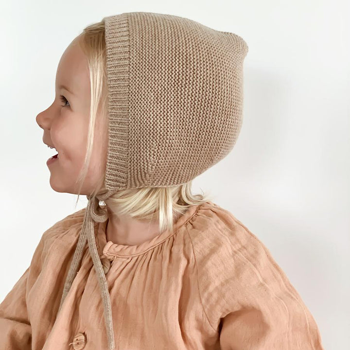 Blonde girl wearing sand beige bonnet