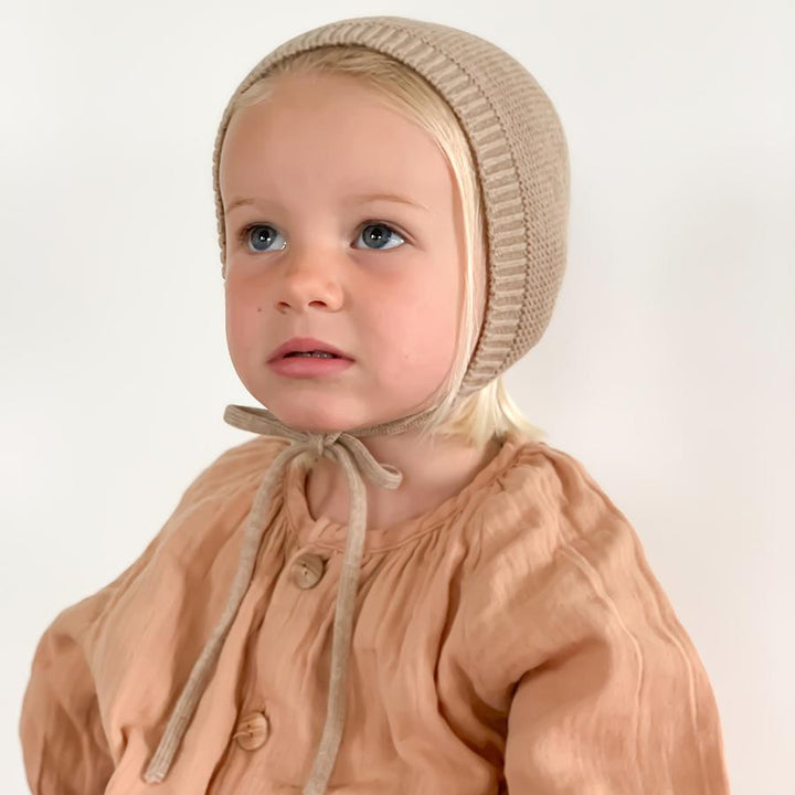 Blonde girl wearing sand beige bonnet
