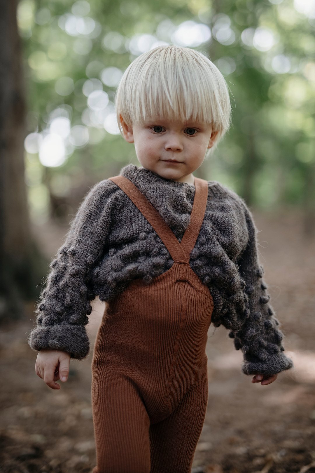 Blonde toddler boy wearing Silly Silas brown cinnamon cotton ribbed tights with braces/suspenders