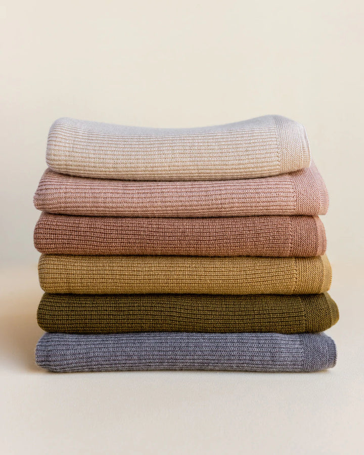 Hvid knitwear stack of folded blankets rib merino wool in grey ochre, mustard, neutral sand white apricot peach 