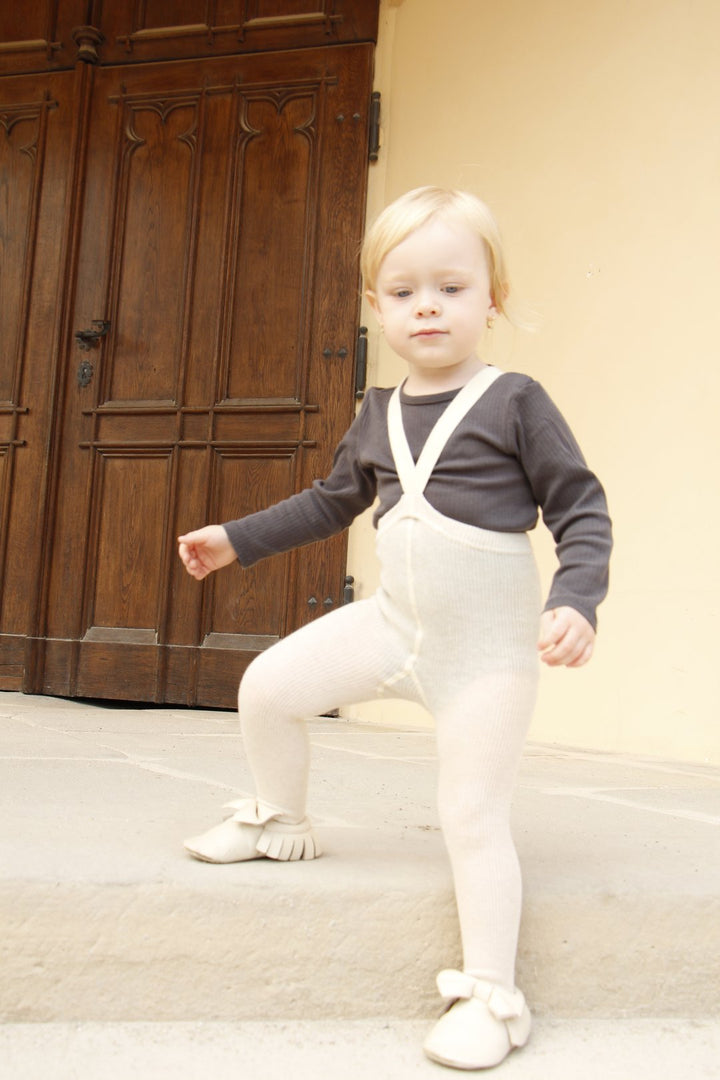 Toddler girl wearing Silly Silas cream beige white cotton ribbed tights with braces/suspenders