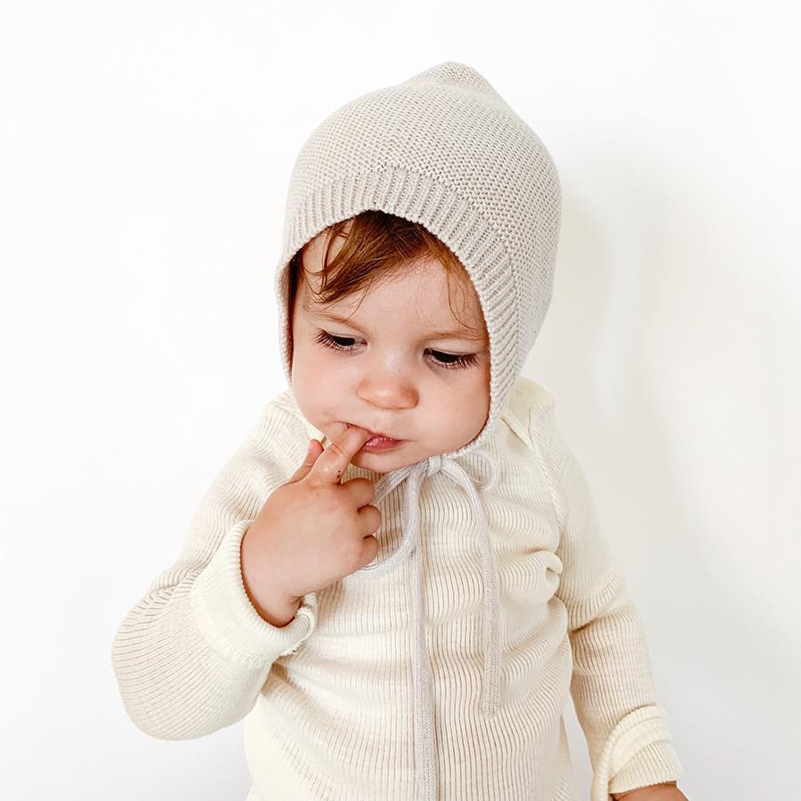 Baby toddler wearing white off-white natural ivory knitted wool bonnet  by Hvid knitwear 