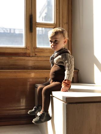 Toddler boy sitting on bench wearing Silly Silas brown cotton ribbed tights with braces/suspenders